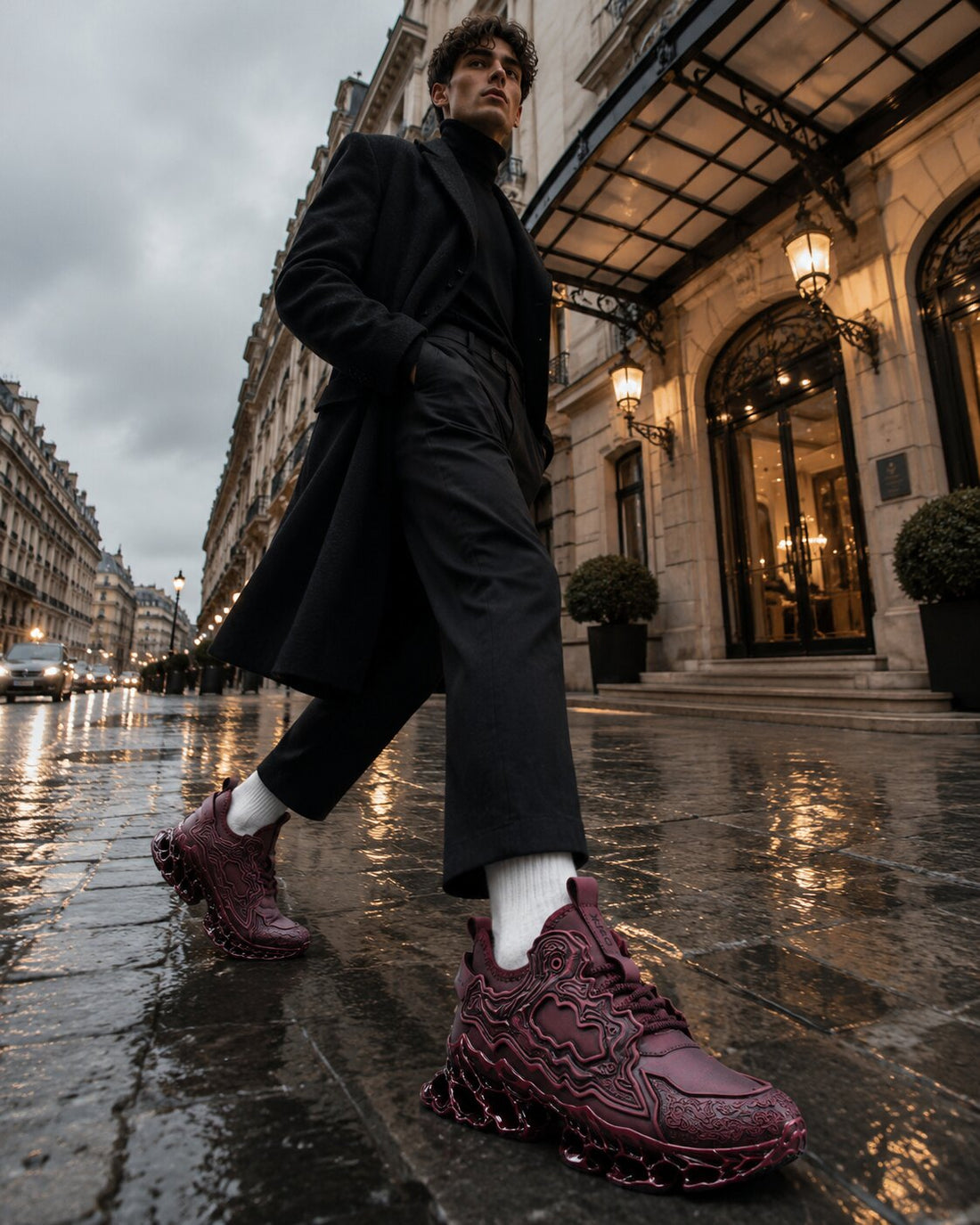 Model in a black overcoat striding along a rain-soaked Paris street in Apex Phantom X9X sneakers in Oxblood Red